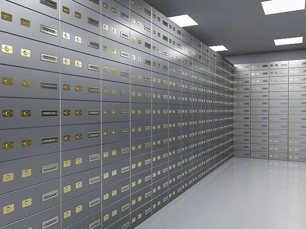 A traditional bank strongroom lined with rows of steel safe deposit boxes.
